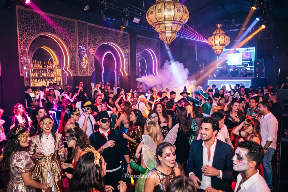 A vibrant Halloween party with costumes in a Gueliz nightclub, representing Marrakech nightlife in October.